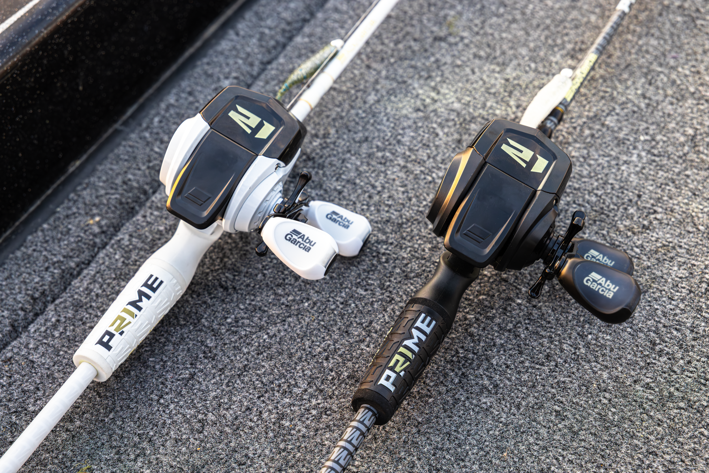 Two Abu Garcia + PRIME21 Collaboration Spincast Combos laying flat on pavement, one black & one white. 
